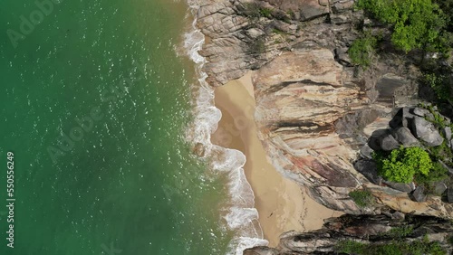 Aerial video of drone flying over beach with waves crashing