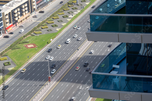 Stone jungle, view from a skyscraper on a multi-lane highway in the center of Dubai. Glass balconies of skyscrapers.