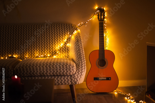 guitar decorated with garland in cozy warm toned interior