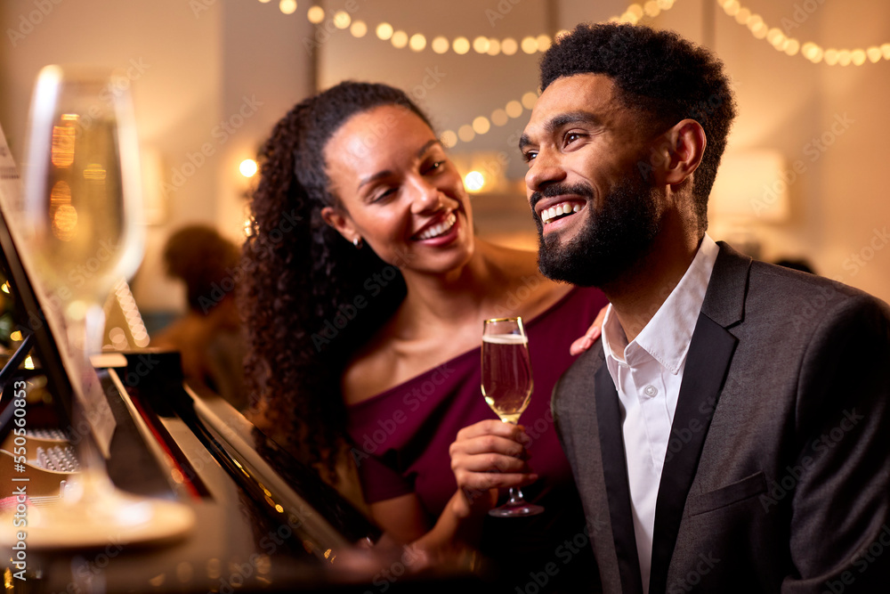 Couple Around Piano Celebrating At Christmas Or New Year Party Together