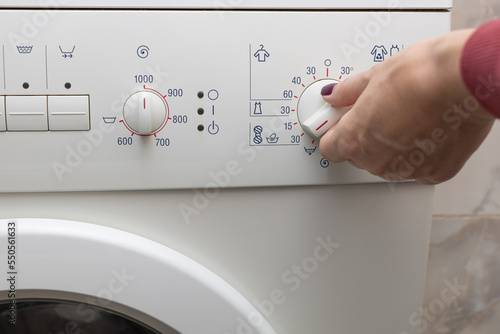 A person chooses a washing mode with a switch.