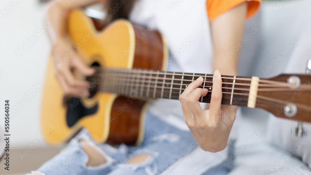 Close up fingers playing guitar strings, Strum to make a sound, Acoustic guitar, Catching guitar chords to create music, Music therapy and meditation practice with playing the guitar.