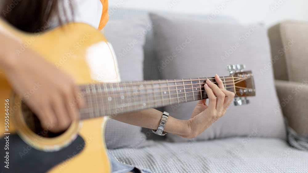 Fototapeta premium Close up fingers playing guitar strings, Strum to make a sound, Acoustic guitar, Catching guitar chords to create music, Music therapy and meditation practice with playing the guitar.