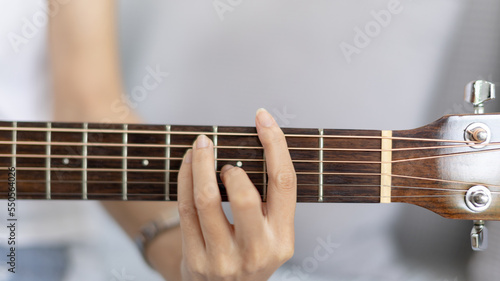 Close up fingers playing guitar strings, Strum to make a sound, Acoustic guitar, Catching guitar chords to create music, Music therapy and meditation practice with playing the guitar.