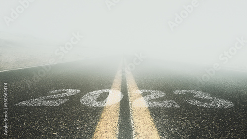 Fotografia 2023 written on an empty asphalt road And ahead is a thick fog