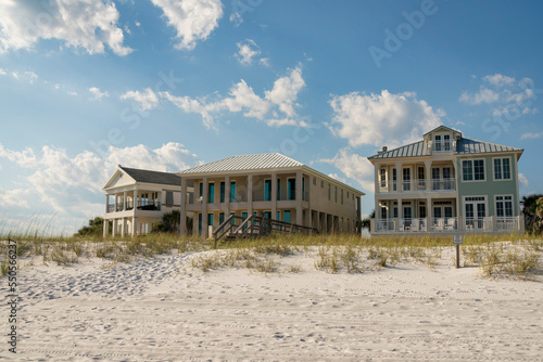 Destin, Florida- Three beach houses facade with wooden footbridge over the sand dunes at the front