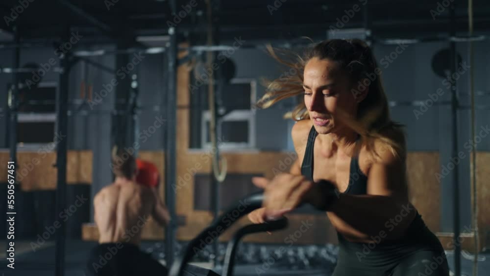 athletic woman is training on stationary bike with handles in gym, portrait shot, slow motion athletic woman is training on stationary bike with handles in gym, portrait shot, slow motion