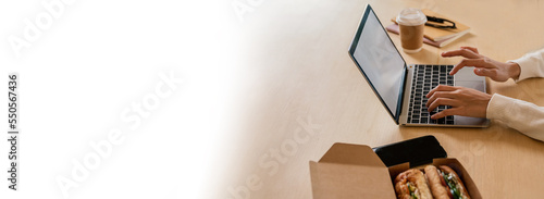 Top view of woman working on project laptop computer, have lunch break eating sandwich on floor, using internet exercise book. Delivery, work from home see, new normal, flat lay background banner