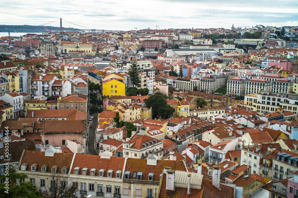 historic buildings of the old town of lisbon. Old colorful buildings, narrow streets, historic churches. Tiled roofs. View from the top of the tenement houses and monuments. Cloudy day
