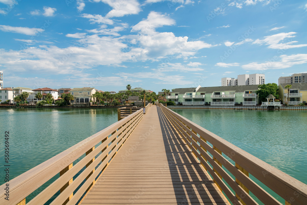 Boardwalk over the brackish water of a lake near the residential area at Destin, Florida