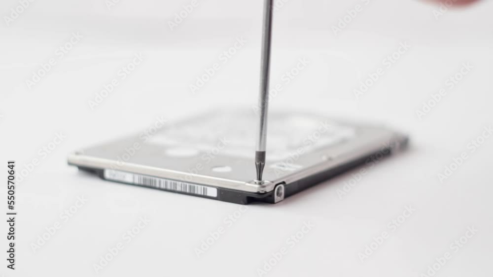 unscrewing the hard drive screw with a screwdriver unscrewing the hard drive screw with a screwdriver