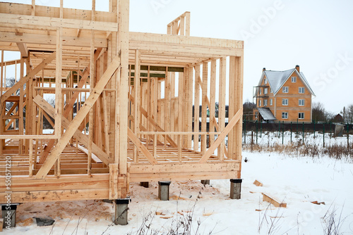 Conventional house construction, bare frame with concrete pile foundation at winter season photo