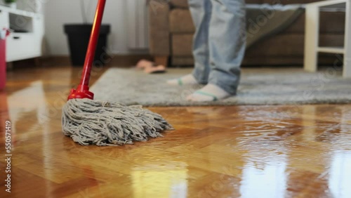Wallpaper Mural Cleaning service. Housewife mopping parquet with wet mop. Close-up of washing floor. Follow shot. Low angle view. Torontodigital.ca