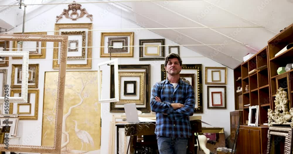 Frame maker standing with arms crossed in his workshop Frame maker standing with arms crossed in his workshop