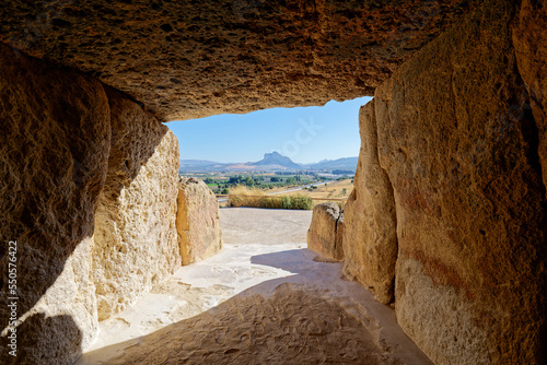 Interior of the megalithic monument Dolmens in Antequera with the natural monument The Lovers' Rock in the background. Touristic travel to Spain. Historic interest and Unesco World Heritage Site. 