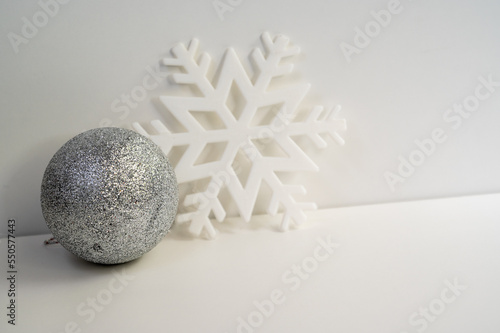 silver Christmas ornaments with white snow flake in white background