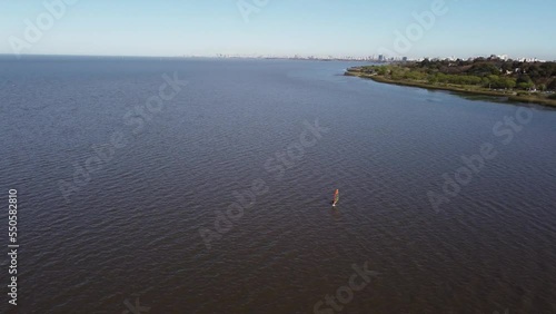 Aerial view of person practicing wind surfing in river Near shore of Vicente Lopez area in Buenos Aires during sunny day photo