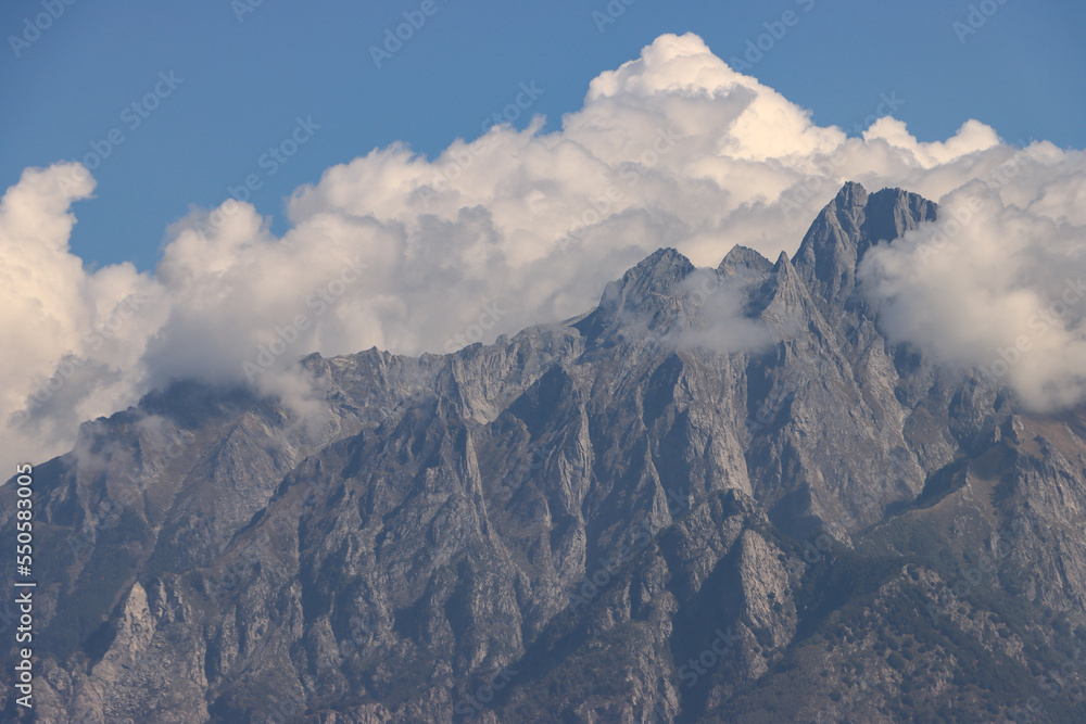 Obraz premium Alpengipfel mit weißer Krone ; Blick vom Comer See (Colico) auf die von Wolken eingerahmten Gipfel im den Sasso Manduino (2888m)