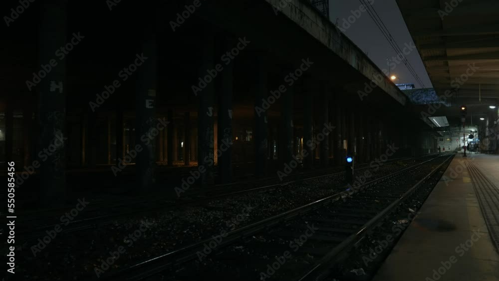 Abandoned railway / subway platform. Ghetto. Rainy autumn foggy weather in the night city. Gotham city mood. Cinematic style. Skyscrapers in the fog. Dungeon columns and dim light. Abandoned railway / subway platform. Ghetto. Rainy autumn foggy weather in the night city. Gotham city mood. Cinematic style. Skyscrapers in the fog. Dungeon columns and dim light.