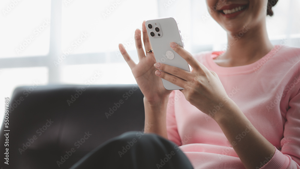 Beautiful Asian woman playing mobile phone in her break from work, she is a marketing manager of a startup company, female leader, supervisor, ceo. Female Leadership Concept. Beautiful Asian woman playing mobile phone in her break from work, she is a marketing manager of a startup company, female leader, supervisor, ceo. Female Leadership Concept.