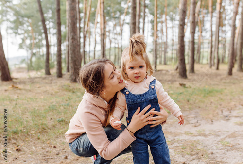 beautiful and happy mother and daughter have a good time in the forest