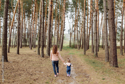 beautiful and happy mother and daughter have a good time in the forest