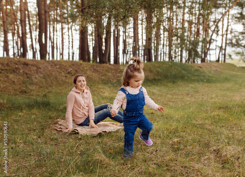 beautiful and happy mother and daughter have a good time in the forest