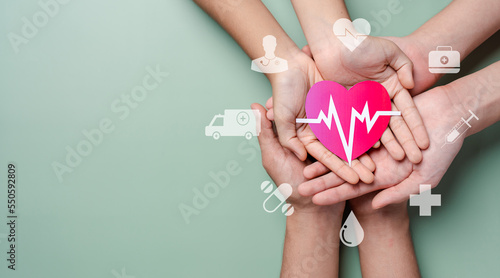 Fototapeta Naklejka Na Ścianę i Meble -  Adult and children hands holding red heart donation with pulse cardiogram, health care, organ donation, family life insurance, world heart day, world health day, praying concept