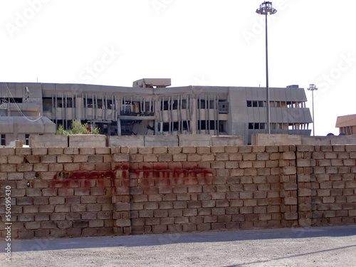 Bombed out building behind a wall on FOB Loyalty in Baghdad, Iraq, during Operation Iraqi Freedom