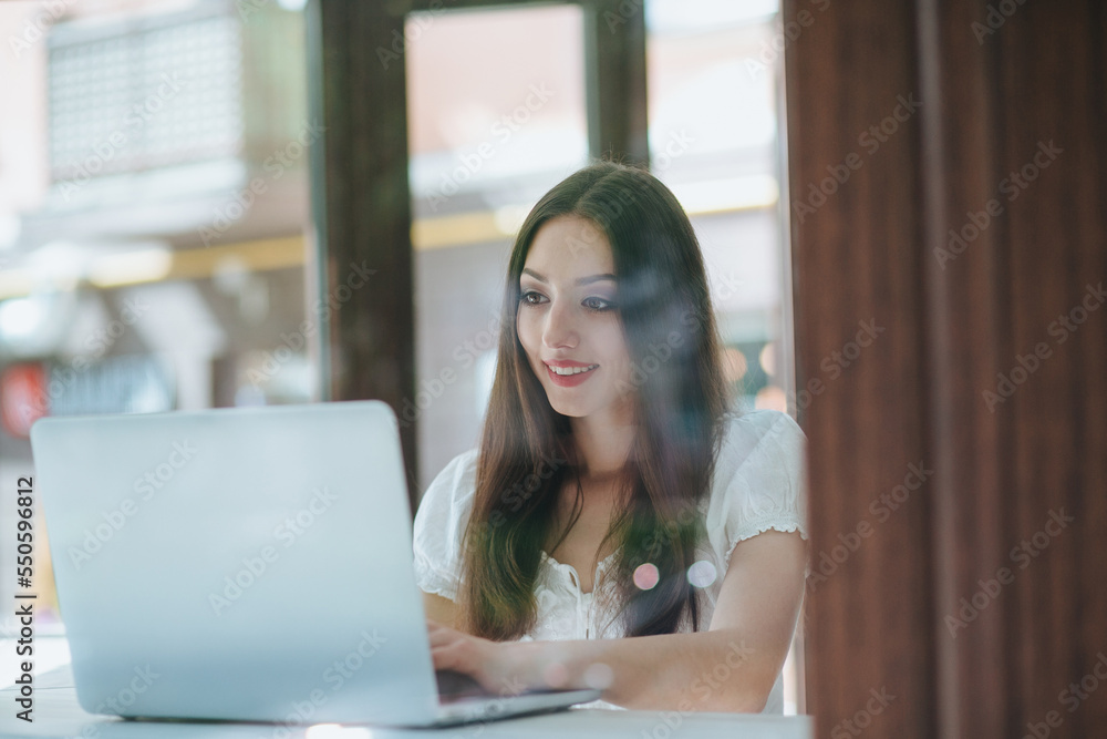 Portrait of beautiful smiling brunette woman sitting in a cafe with laptop outdoor. Portrait of beautiful smiling brunette woman sitting in a cafe with laptop outdoor.