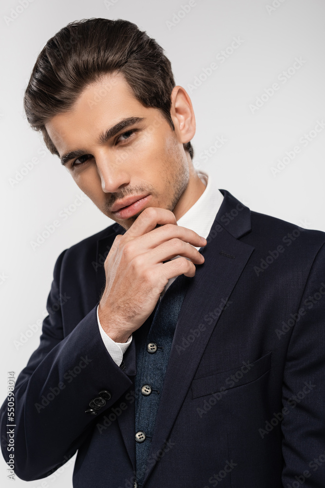 good looking and young businessman in formal wear looking at camera isolated on grey good looking and young businessman in formal wear looking at camera isolated on grey