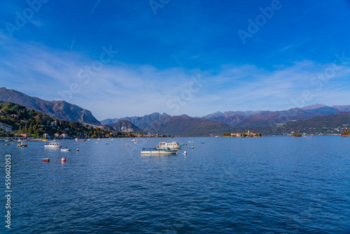 Small wood boats at the lake Maggiore at Stresa, landscapes over the lake in the backgound the alps