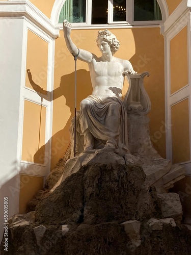 Vertical shot of a sculptural portrait of Roman emperor Adrian Antinous with a harp,against the wall photo