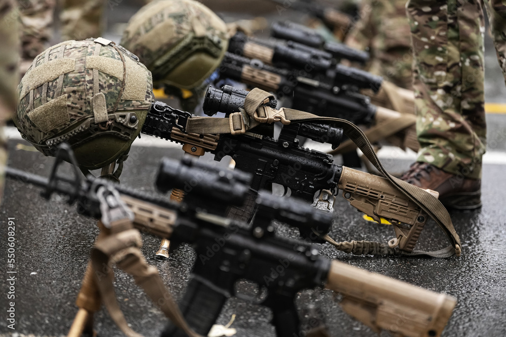 Obraz premium Military equipment concept image. Close up view of a sniper machine gun with the military protective helmet above standing on the ground.