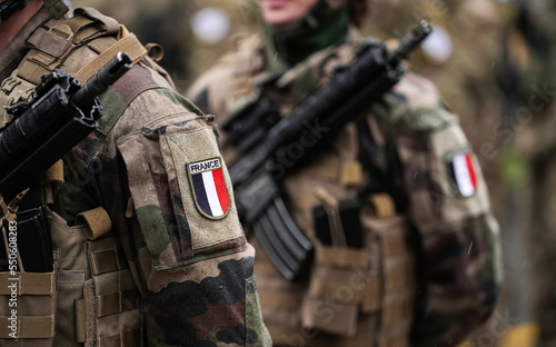 France Army soldiers uniform. Close up photo with the France flag on a military soldier uniform with the gun next to it. Military industry concept photo.