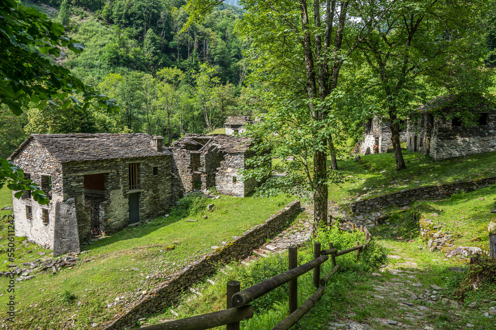 Ruined stone houses and mills in an abandoned mountain village in the Alps