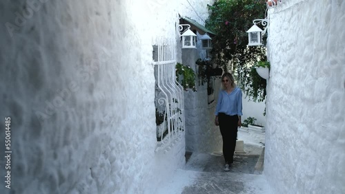 a woman walks along the narrow white street of the city of Marmaris Turkey