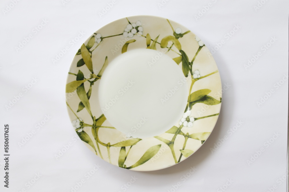 Top shot of ceramic dining plates with floral and leaf design Top shot of ceramic dining plates with floral and leaf design