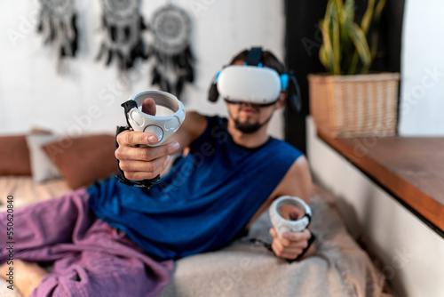 Young man using virtual reality headset at home