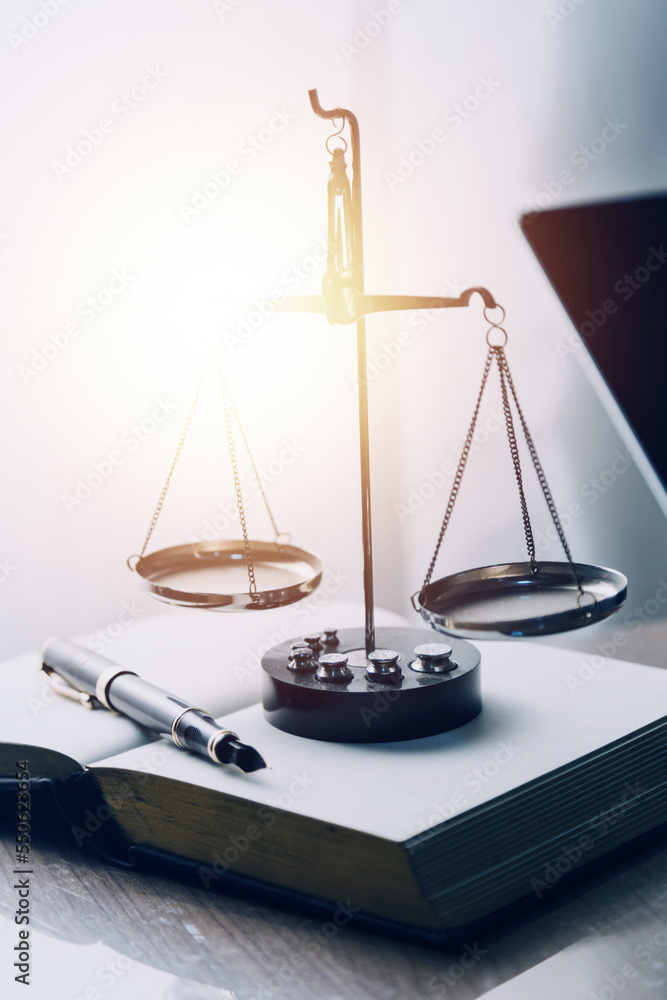 Justice and law concept.Male judge in a courtroom with the gavel, working with, computer and docking keyboard, eyeglasses, on table in morning light Justice and law concept.Male judge in a courtroom with the gavel, working with, computer and docking keyboard, eyeglasses, on table in morning light