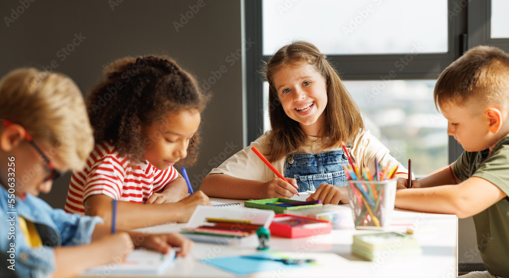 Fototapeta premium Cheerful multiracial children solving test with classmates