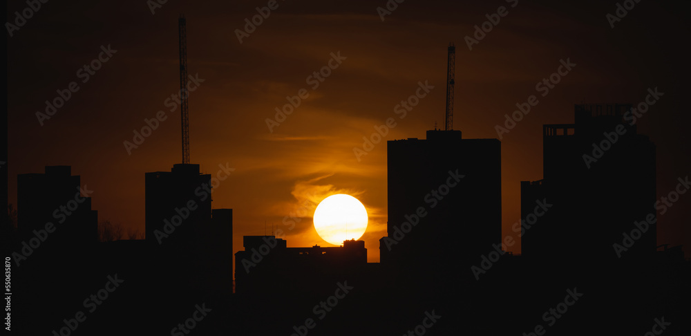 Sunset moment, golden sun, city skyline silhouette