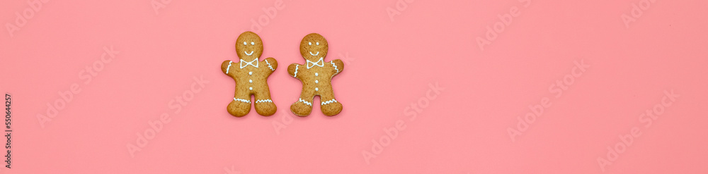 Banner with Christmas gingerbread and Christmas tree branches on a pink background. Place for text on top. The concept of festive New Year's baking Banner with Christmas gingerbread and Christmas tree branches on a pink background. Place for text on top. The concept of festive New Year's baking