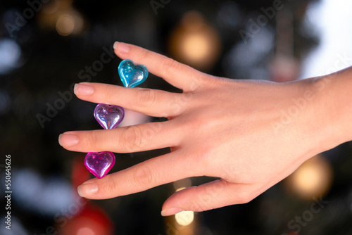 female hand holding multi-colored glass hearts