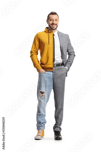 Young man wearing suit and tie on one half and jeans and hoodie on other half photo