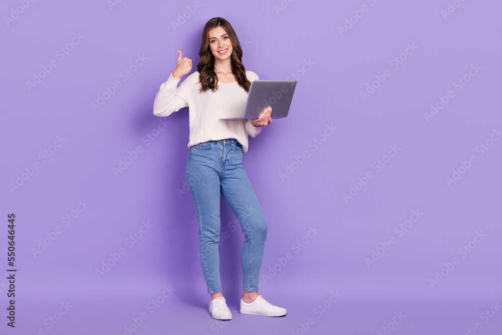 Full length photo of charming pretty lady use netbook hand thumb up satisfied modern gadget empty space isolated on purple color background Full length photo of charming pretty lady use netbook hand thumb up satisfied modern gadget empty space isolated on purple color background