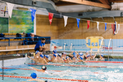 Coach speaking to kids in pool