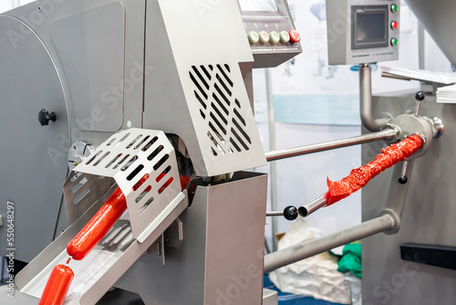 Fotografie sausage after filling and during pass portioning outlet and casing holding tube