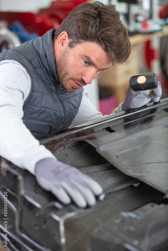 coachbuilder using a hammer to bend a car door coachbuilder using a hammer to bend a car door