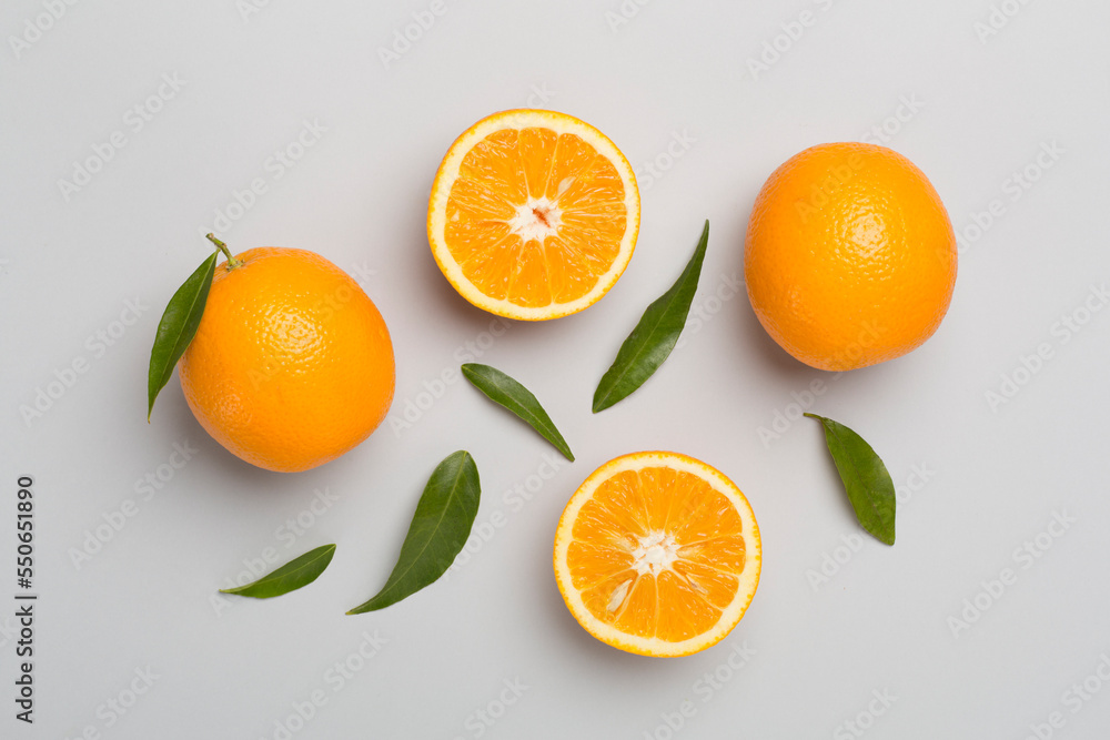 Flat lay with fresh oranges and leaves on color background Flat lay with fresh oranges and leaves on color background